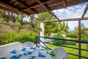 a table and chairs on the balcony of a house at Green Eden home near the beach in Skála Foúrkas