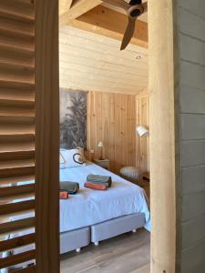 ein Schlafzimmer mit einem Bett in einem Zimmer mit Holzwänden in der Unterkunft VillaCanau in Lacanau