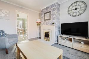 ein Wohnzimmer mit einem TV und einem Kamin in der Unterkunft Comfy Home Ideal for Groups - Free Parking in Bedford
