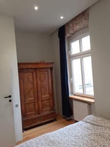 - une chambre avec une armoire en bois et une fenêtre dans l'établissement Riverside Retreat on Parkowa, à Wrocław