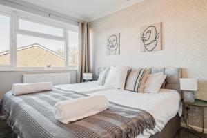 ein Schlafzimmer mit einem großen Bett und einem Fenster in der Unterkunft Comfy Home Ideal for Groups - Free Parking in Bedford