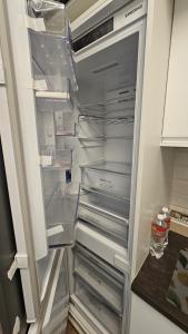 an empty refrigerator with its door open in a kitchen at Apartament Anastazja FREE PARKING in Krakow