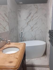 La salle de bains est pourvue d'une baignoire blanche et d'un lavabo. dans l'établissement Riverside Retreat on Parkowa, à Wrocław