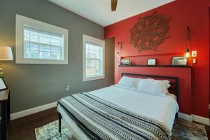 Un dormitorio con una pared roja y una cama en Movie Lover's Gem - Steps from Metro & the Capitol!, en Washington
