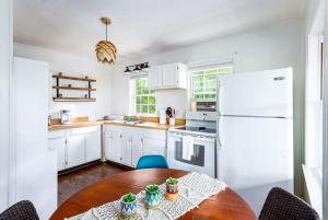 a kitchen with a table and a white refrigerator at Shenandoah mountain cottage w hot tub & fire pit in Front Royal