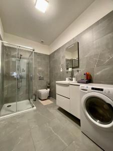 ein Bad mit einer Dusche und einer Waschmaschine in der Unterkunft NEW, BEAUTIFUL APT WITH PARKING IN BEST LOCATION! in Bratislava