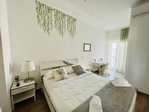 a white bedroom with a large bed and a window at Vivinà_081 in Naples