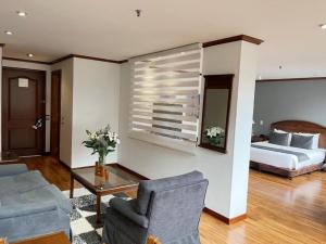 a living room with a bed and a room with a couch at Hotel Bogotá Regency Usaquén in Bogotá