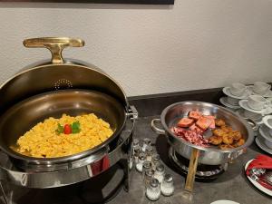 Hotel Haus Christel في فيلنغن: وعاء من الأرز واللحوم على موقد