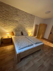 a bedroom with a bed and a brick wall at ANNA Gästehaus Zimmer in Pfreimd