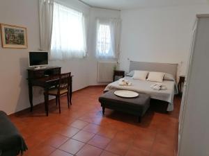 1 dormitorio con cama, mesa y escritorio en Grazioso appartamento tra cultura, lago e montagna, en Pomarolo