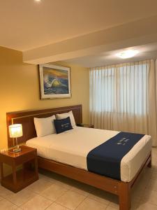 Un dormitorio con una cama grande y una ventana en Lucky Star Hotel, en Chiclayo