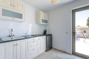 a white kitchen with a sink and a dishwasher at Villa Daniela Studio in Neokhórion +15 photos