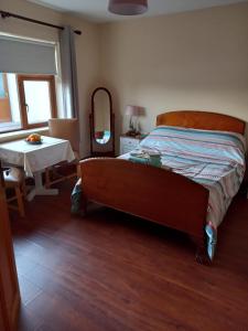 1 dormitorio con cama, mesa y espejo en Four Seasons en Waterford