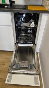an open dishwasher in a kitchen with its door open at Apartament Anastazja FREE PARKING in Krakow