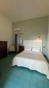 um quarto com uma cama branca e uma cadeira em Suites Edivino Design Capri em Capri
