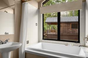 a bathroom with a tub and a sink and a window at El Capitan Canyon in Capitan