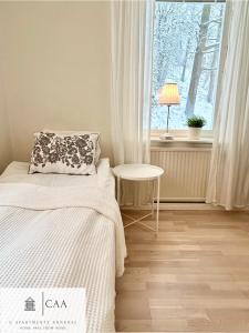 a bedroom with a bed and a table and a window at C Apartments Annedal in Gothenburg