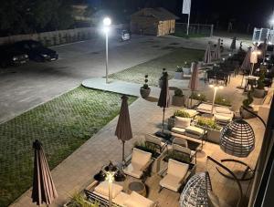 an outdoor patio with chairs and umbrellas at night at Holdvirág Hotel in Sárvár