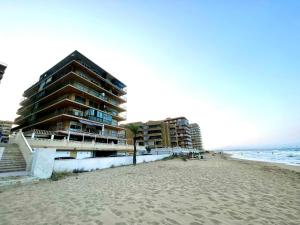 um edifício na praia junto ao oceano em Arenales del sol, primera linea de playa em Arenales del Sol