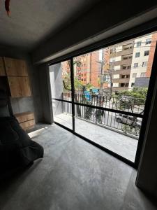 a room with a large window with a view of a city at Apartaestudio tipo loft nuevo in Medellín