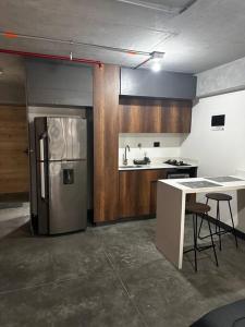 a kitchen with a stainless steel refrigerator and a counter at Apartaestudio tipo loft nuevo in Medellín