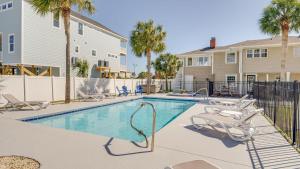 una piscina con sillas y palmeras en Key West House- 2nd Row- Beach House-Cherry Grove, en Myrtle Beach