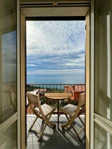 balcón con mesa, sillas y vistas al océano en Creuza de Cinque Terre Apartment, en Volastra
