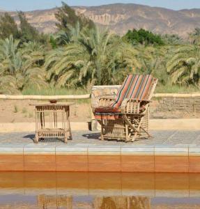 krzesło siedzące obok stołu obok stołu w obiekcie Five oasis desert camp w mieście Az Zabū