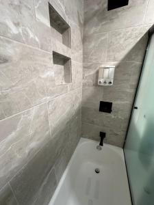 a bathroom with a white tub and a sink at 2BR Gem: Modern Comfort & Style in Cheyenne