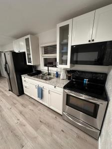 eine Küche mit weißen Schränken und Küchengeräten aus Edelstahl in der Unterkunft 2BR Gem: Modern Comfort & Style in Cheyenne