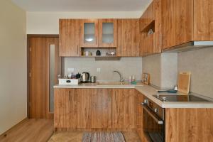 a kitchen with wooden cabinets and a sink at Central Area Retreat AC & WiFi in Varna City