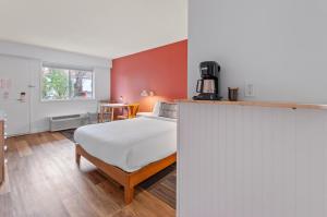 a bedroom with a large bed and a table at Okanagan Lakefront Resort in Penticton