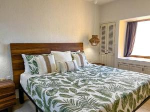 um quarto com uma cama com um edredão verde e branco em Princesa de Peñasco Condo D203 Sandy Beach Puerto Peñasco em Puerto Peñasco