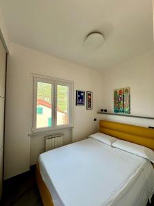 1 dormitorio con 1 cama blanca grande y ventana en Creuza de Cinque Terre Apartment, en Volastra