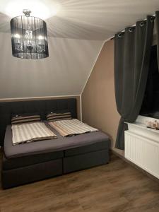 1 dormitorio con cama y lámpara de araña en Ferienwohnung Rosa - b48939, en Horn-Bad Meinberg