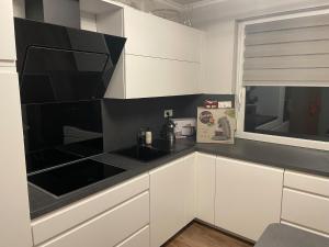 a kitchen with white cabinets and black counter tops at Ferienwohnung Rosa - b48939 in Horn-Bad Meinberg