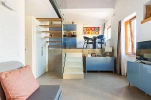 uma sala de estar com uma escada que leva a uma cozinha com armários azuis em Agrigento Luxury Suite Kandinskij em Agrigento