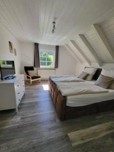 a bedroom with a bed and a desk and a chair at Ferienwohnung im Ferndorftal in Hilchenbach