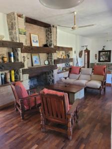 a living room with a couch and chairs and a fireplace at Casas de Campo in Santa María