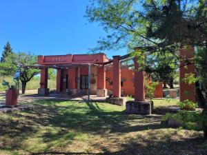 an old red building with trees in front of it at Casona y Casa de Campo in Santa María