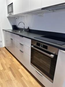 a kitchen with a sink and a stove at Fresh Apartment in Stockholm