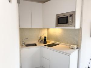 een witte keuken met witte kasten en een magnetron bij Inmejorable Ubicación en Madrid in Madrid