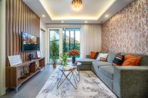 a living room with a couch and a tv at LaVida Deluxe villa Hajdúszoboszló in Hajdúszoboszló