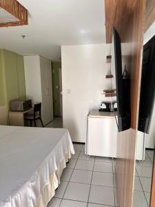 1 dormitorio con 1 cama y TV de pantalla plana en Gran Lençóis Flat Residence, en Barreirinhas