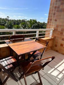 un tavolo in legno e 2 sedie sul balcone di Gran Lençóis Flat Residence a Barreirinhas