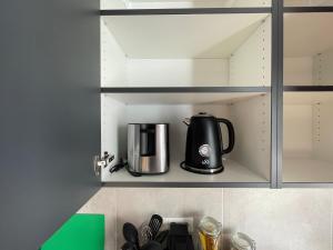 a coffee maker is sitting in a cupboard at Rooftop Suite Essen Central-Fair-HBF-Uniklinik-Balcony-Walk-In Shower-Coffee station-WiFi-Workspace in Essen