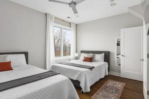 a white bedroom with two beds and a window at Modern Luxury Rooftop Deck, 3 mi to Downtown in Nashville