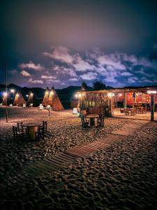 una playa con mesas y tiendas de campaña por la noche en M beach, 