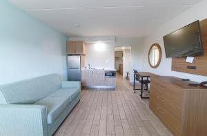 Seashire Inn & Suites في فرجينيا بيتش: غرفة معيشة مع أريكة ومطبخ